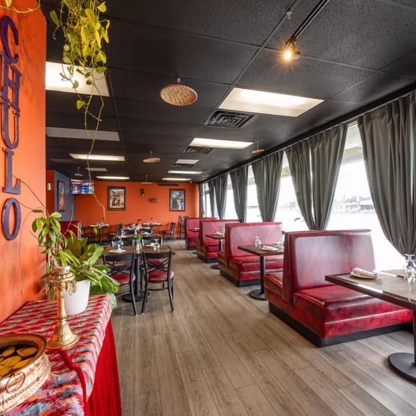 Chulo Cuisine of Nepal & India dining room with red booths, tables, and orange walls.
