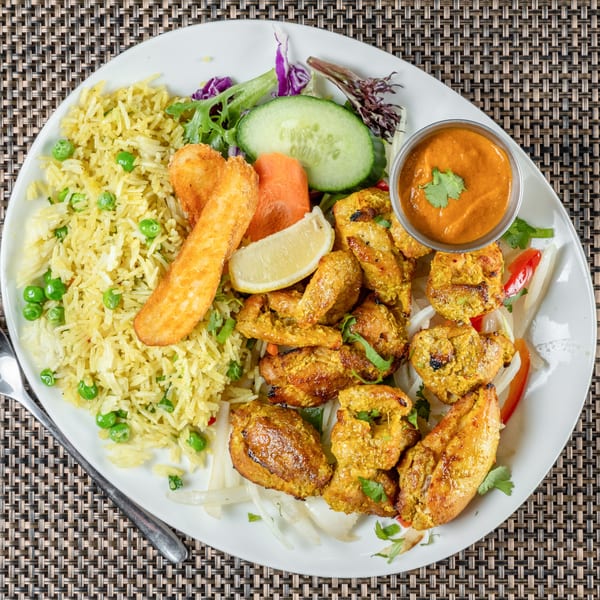 Chulo Cuisine of Nepal & India's chicken tikka with rice, salad, and dipping sauce.